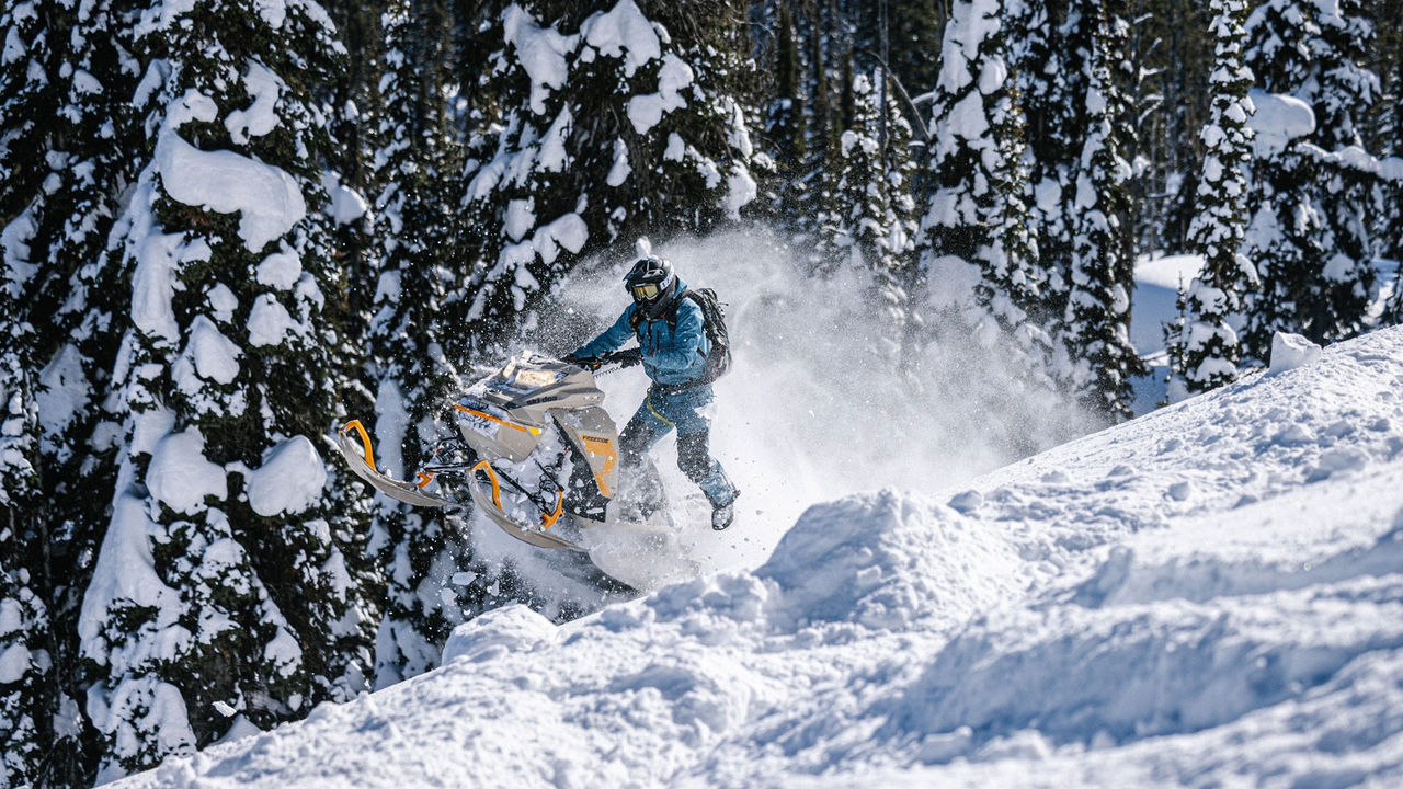 Blaine Mathews riding a Ski-Doo snowmobile in mountain