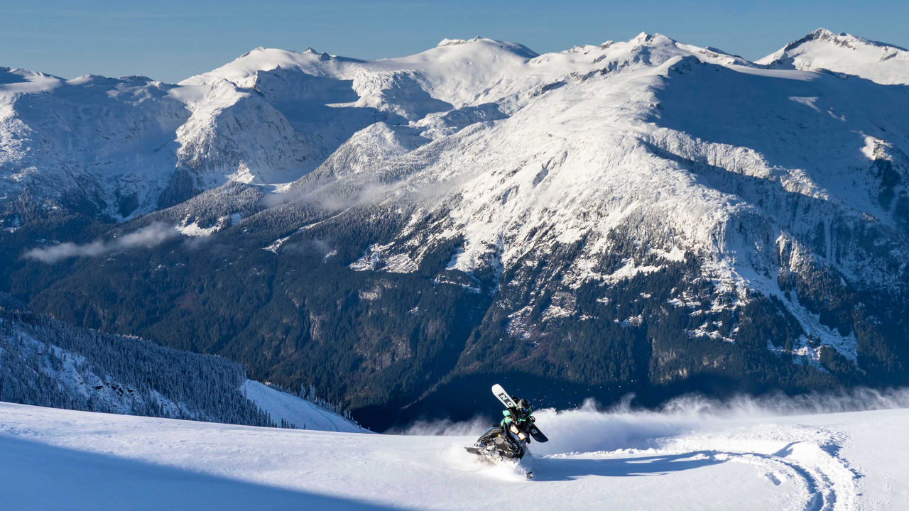 Craig McMorris riding a Ski-Doo Snowmobile in a mountain