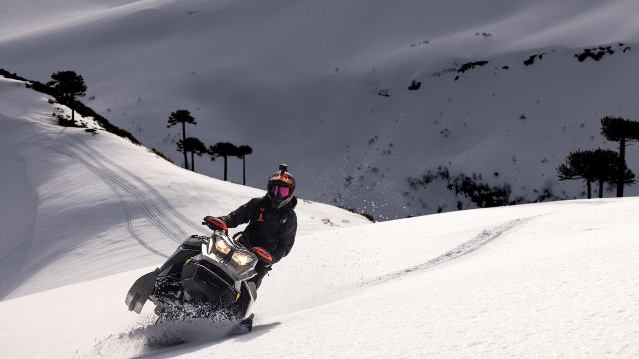 Homme conduisant un Ski-Doo dans la neige profonde au Chili
