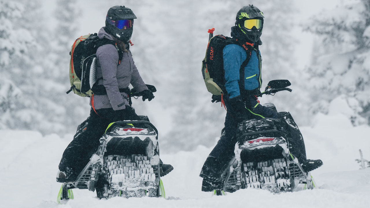 Two Ski-Doo riders looking at their environment