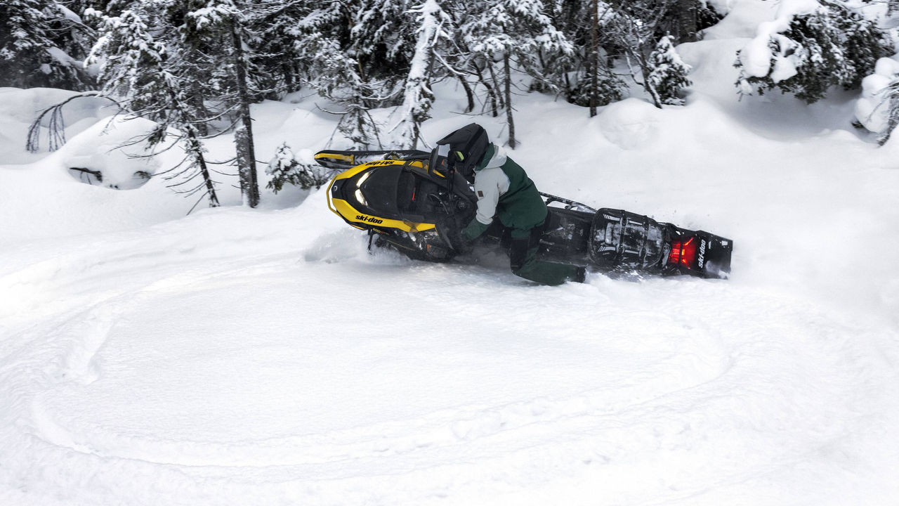Woman carving through powder with a Ski-Doo Backcounty Adrenaline