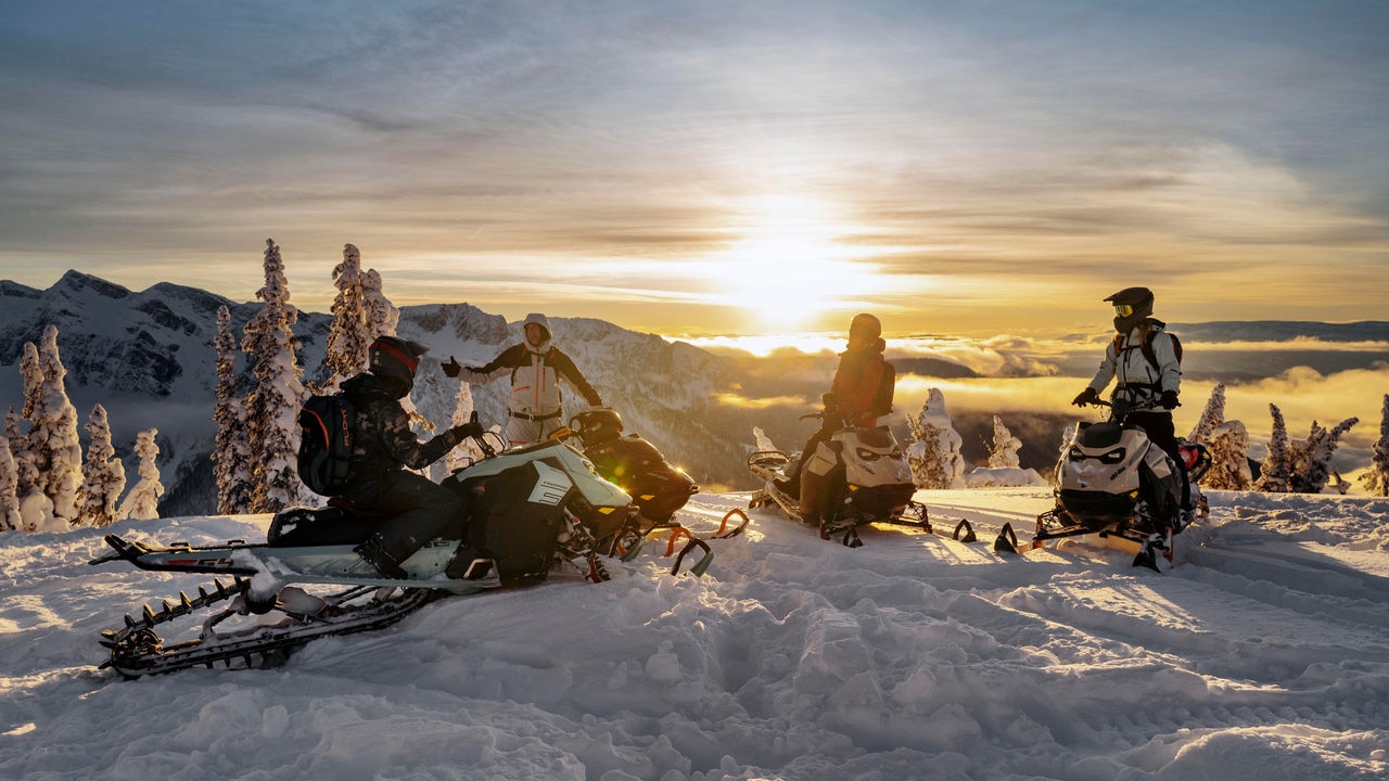 Groupe d'amis profitant d'une journée sur la neige avec leurs motoneiges Ski-Doo