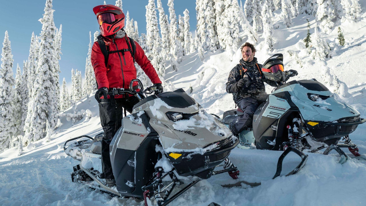 Deux motoneigistes Ski-Doo dans une montagne