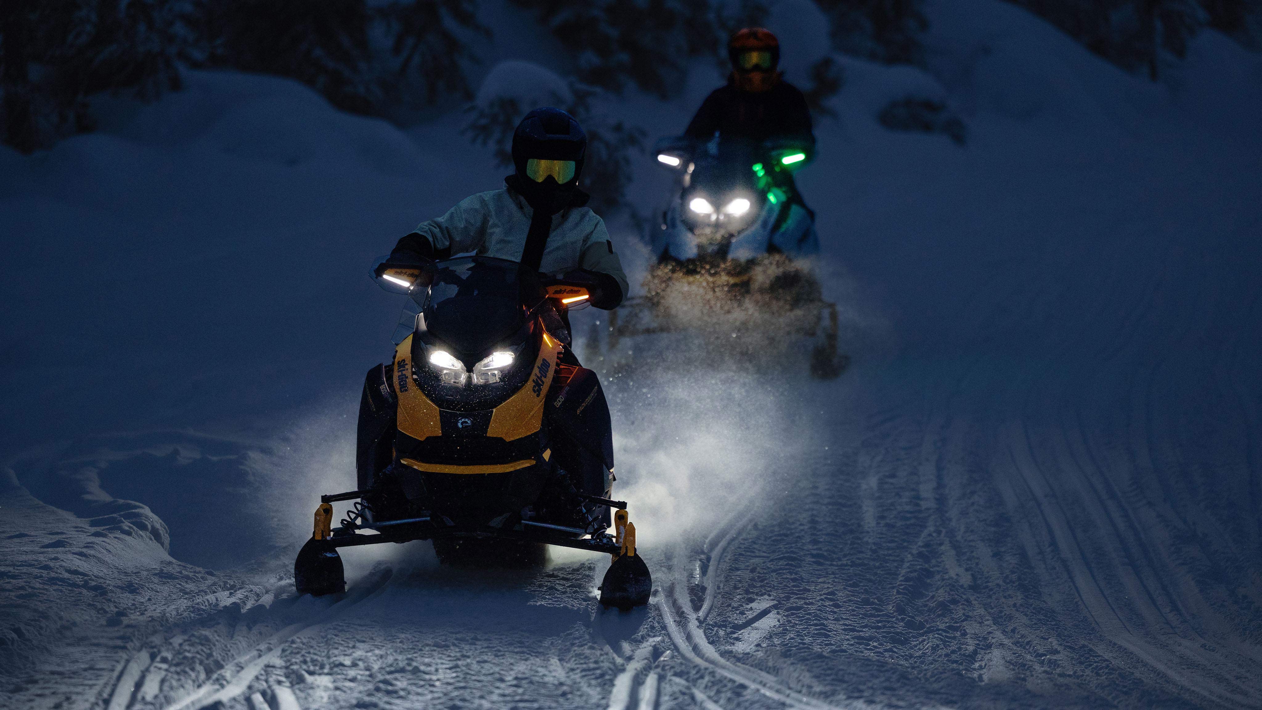 Two snowmobilers in trail using the new LED Running Lights for Handguards
