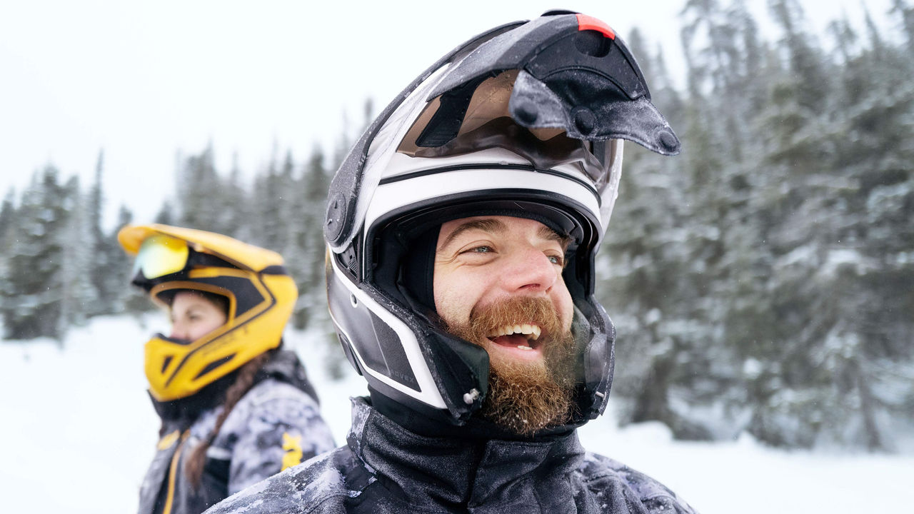 Two riders wearing Ski-Doo apparel in trail