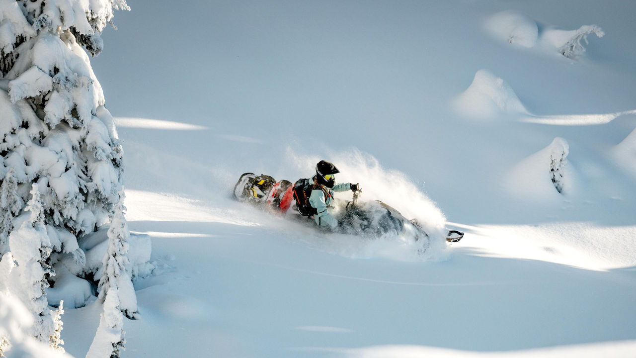 雪上、アクセサリーを装着したSki-Doo Summitに乗っている女性