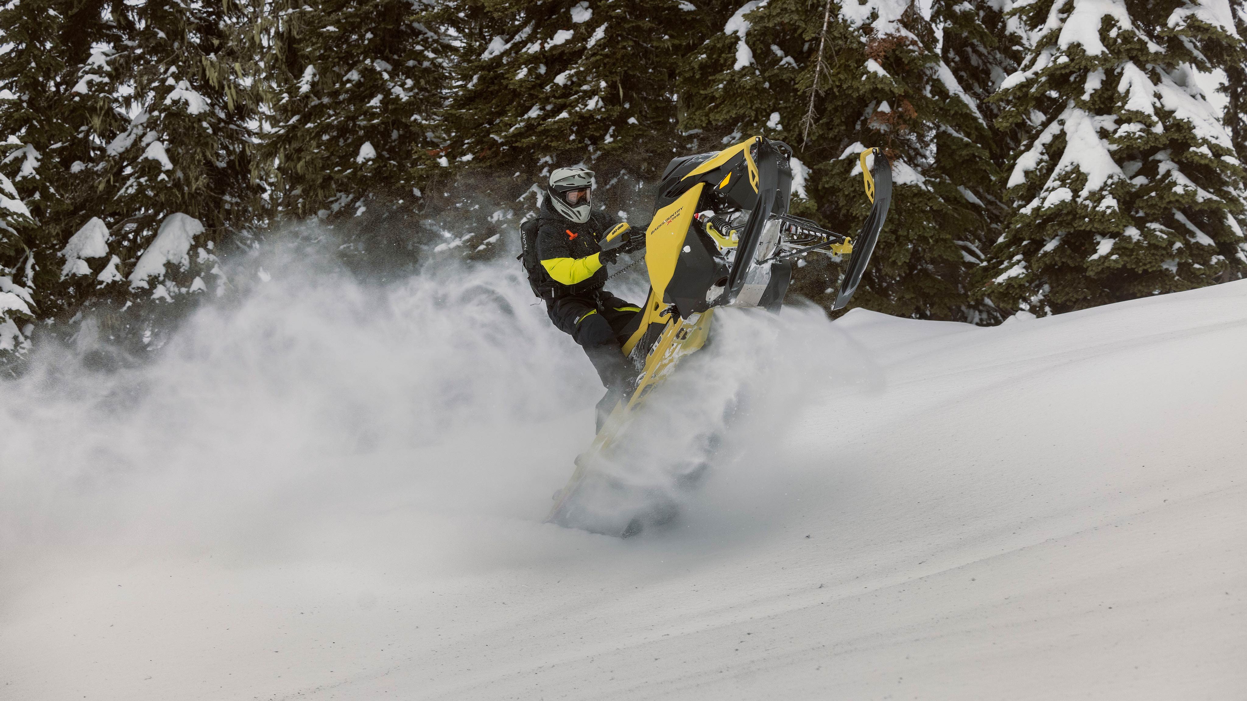 Rider pulling off a trick on a Ski-Doo Backcountry crossover snowmobile in deep snow