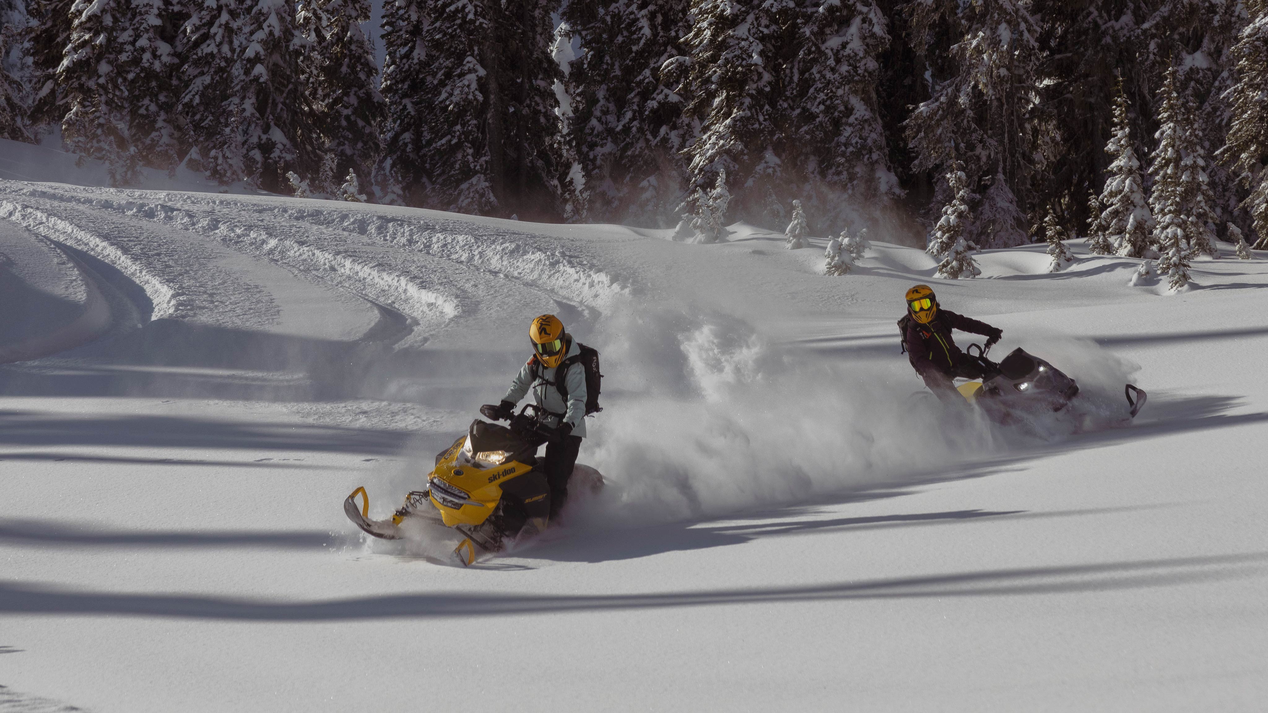 Two 2025 Ski-Doo snowmobiles riding in deeps snow