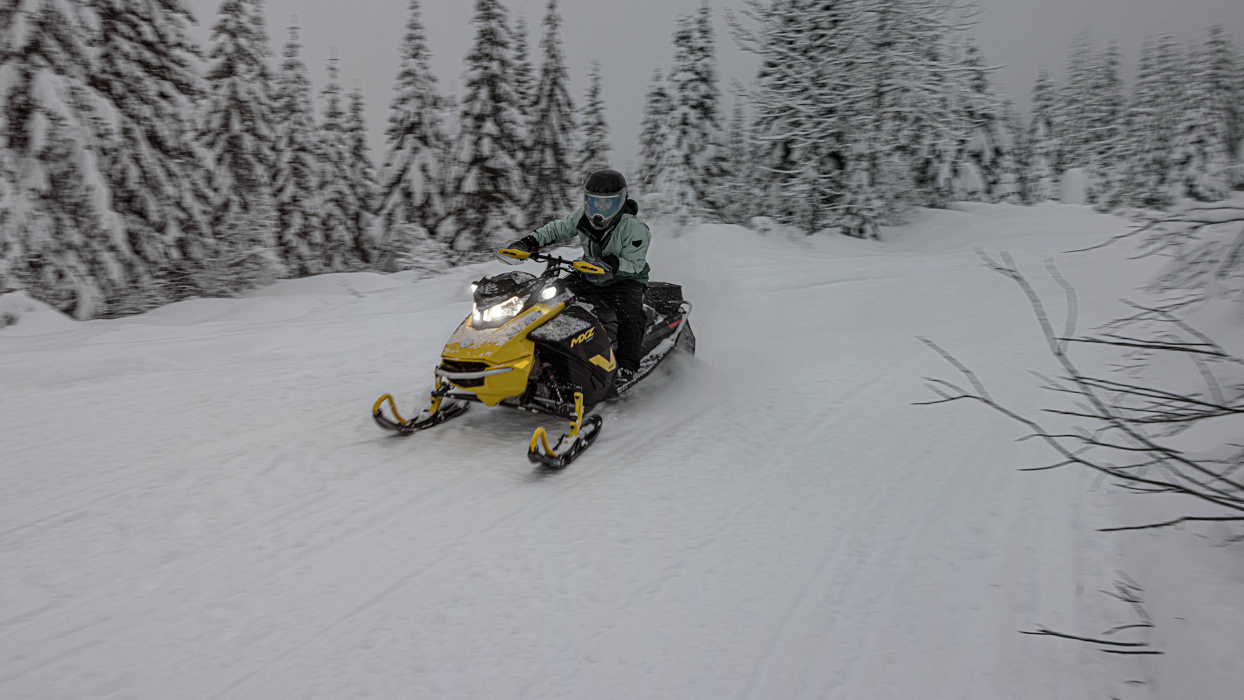 2025 trail snowmobile Ski-Doo MXZ NEO riding through a forest