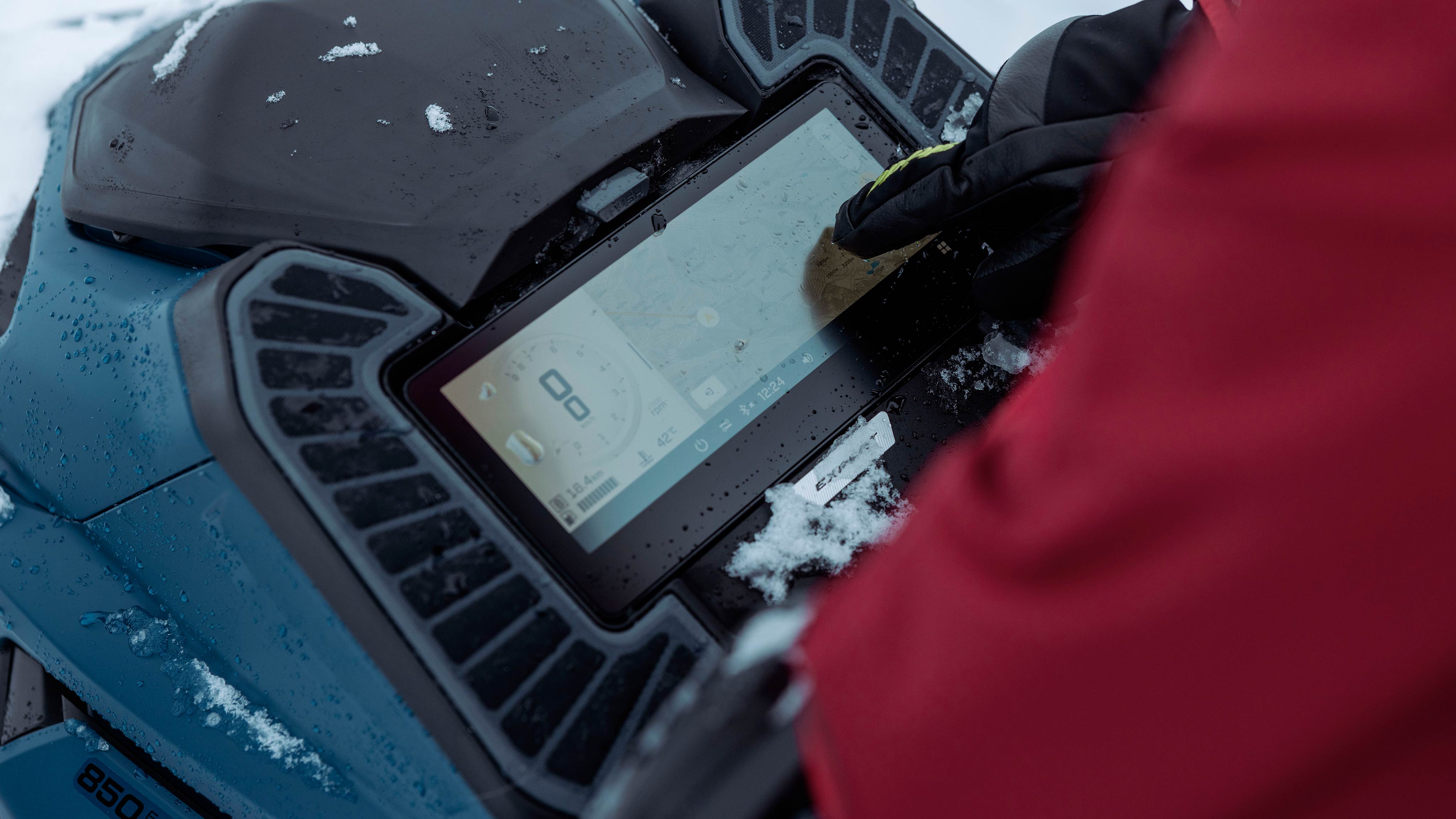 Un motoneigiste qui utilise l'écran tactile 10.25 pouces du Ski-Doo Summit 2025