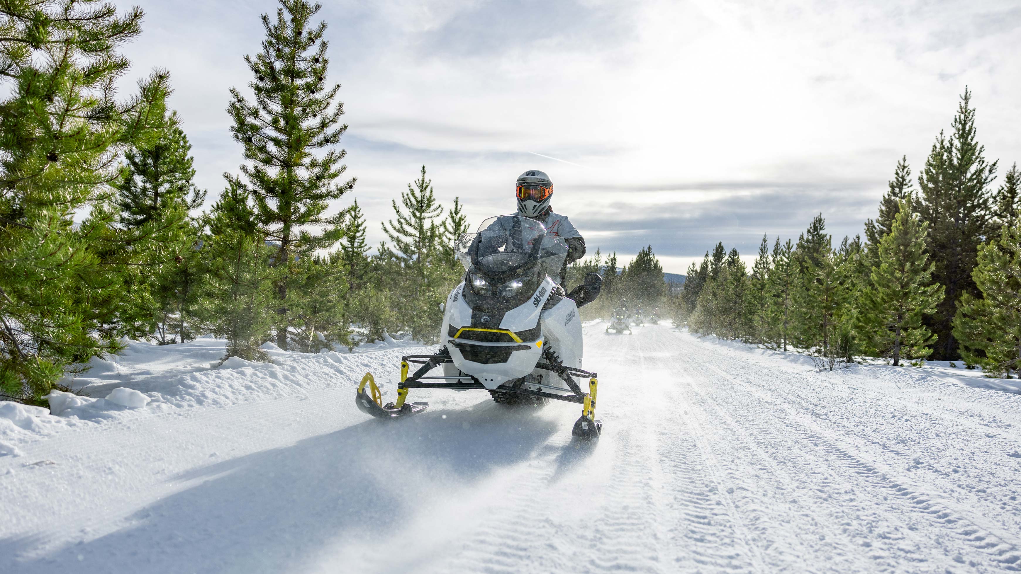 Group of snowmobilers in trail with Grand Touring Electric sleds