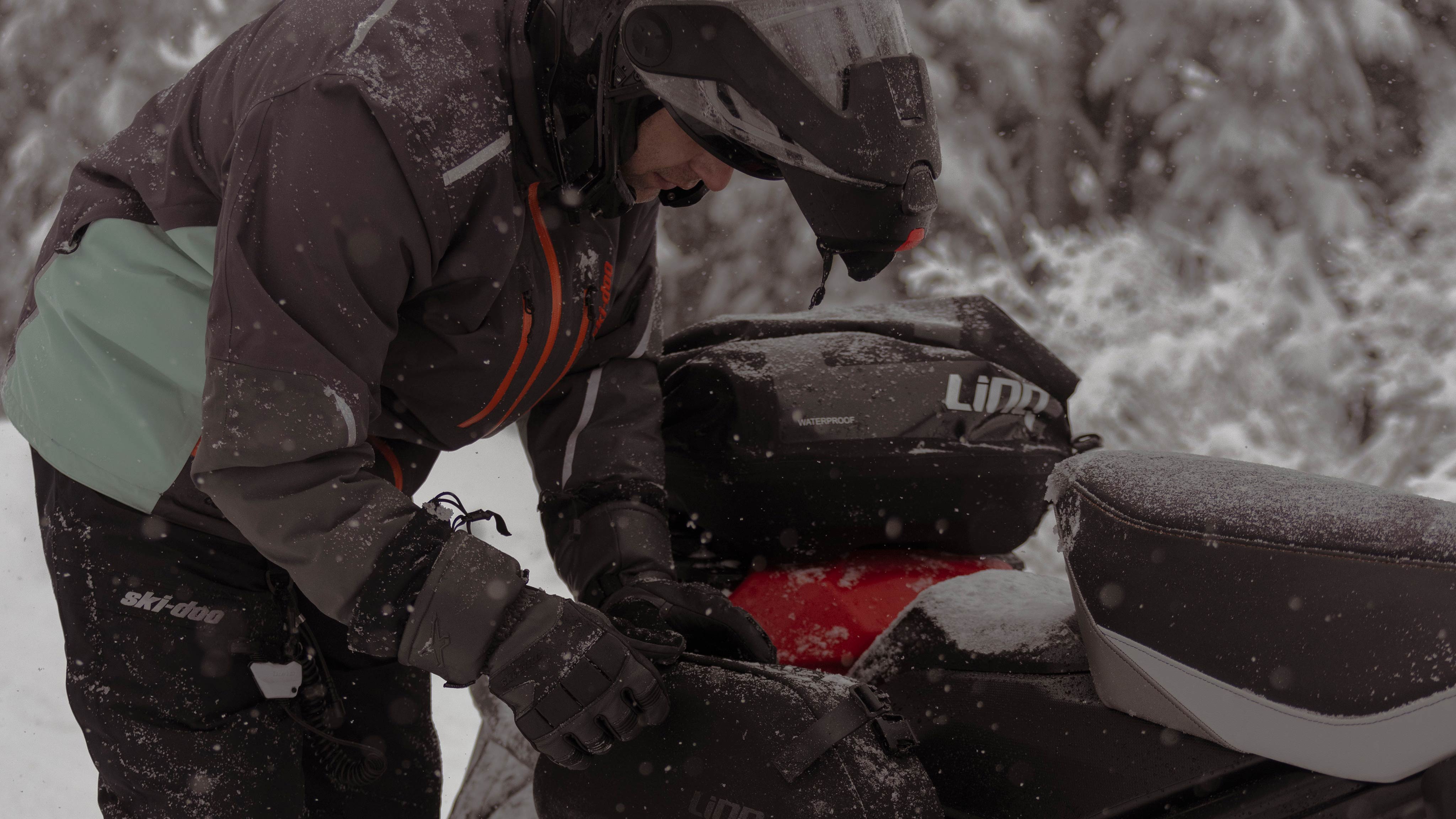 Snowmobile rider using LinQ storage bags