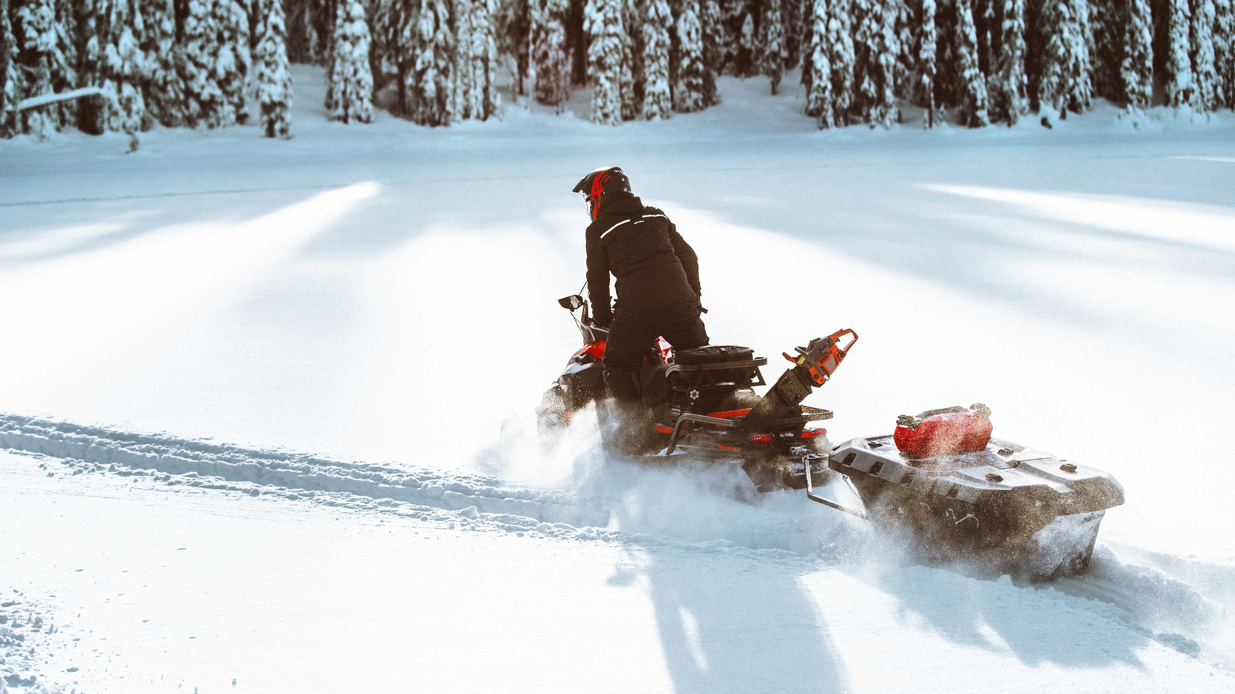 Man riding a Ski-Doo Skandic with sleigh in Deep-Snow