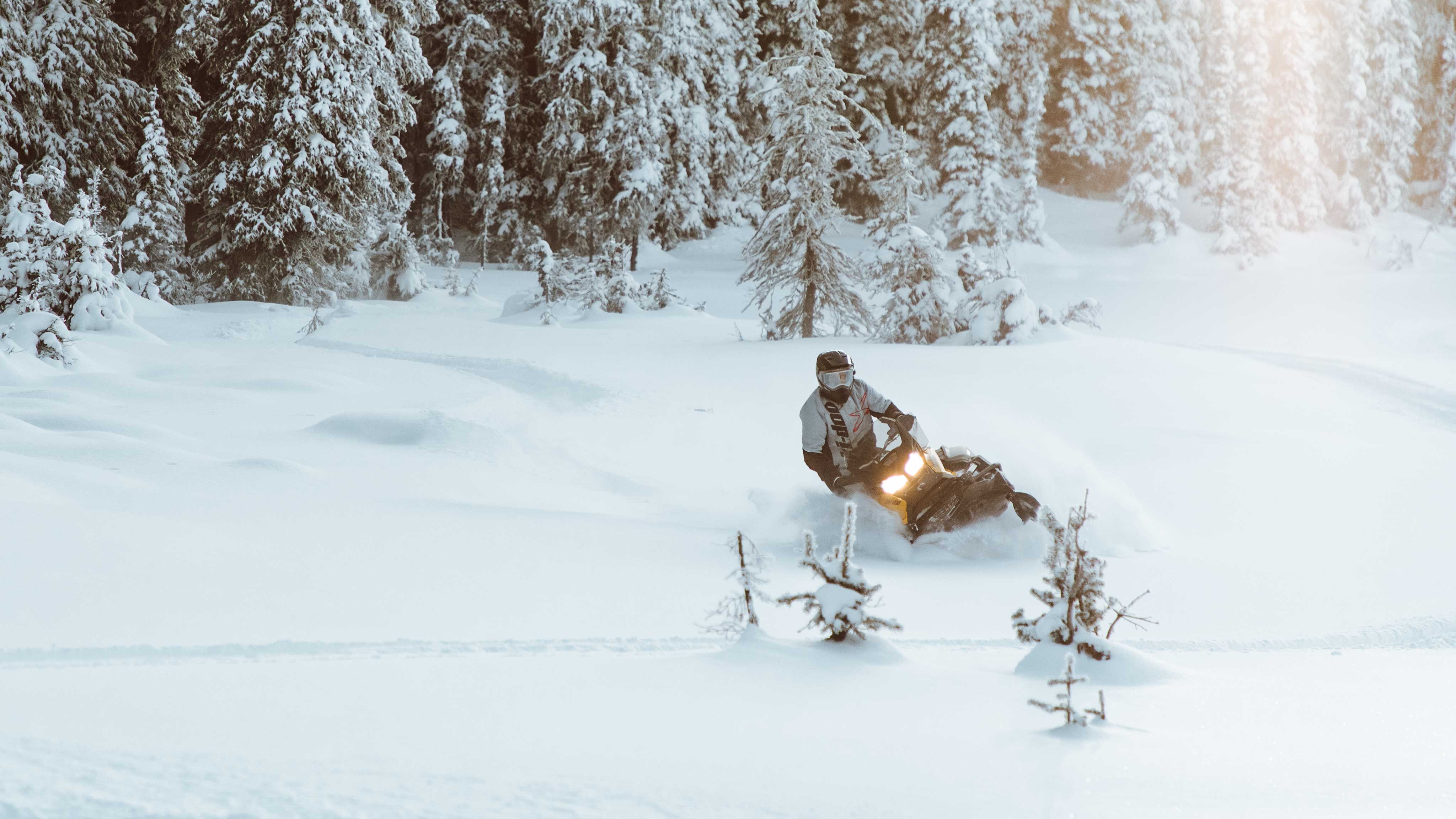 Homme debout sur Ski-Doo Tundra dans la neige profonde