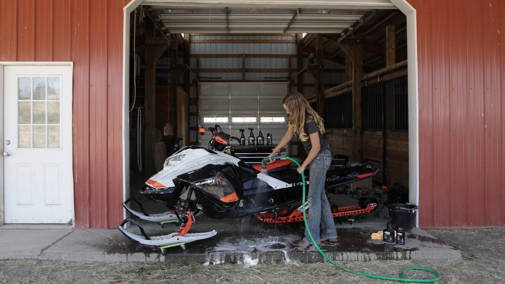 Stefanie Dean cleaning her Ski-Doo snowmobile before summer storage