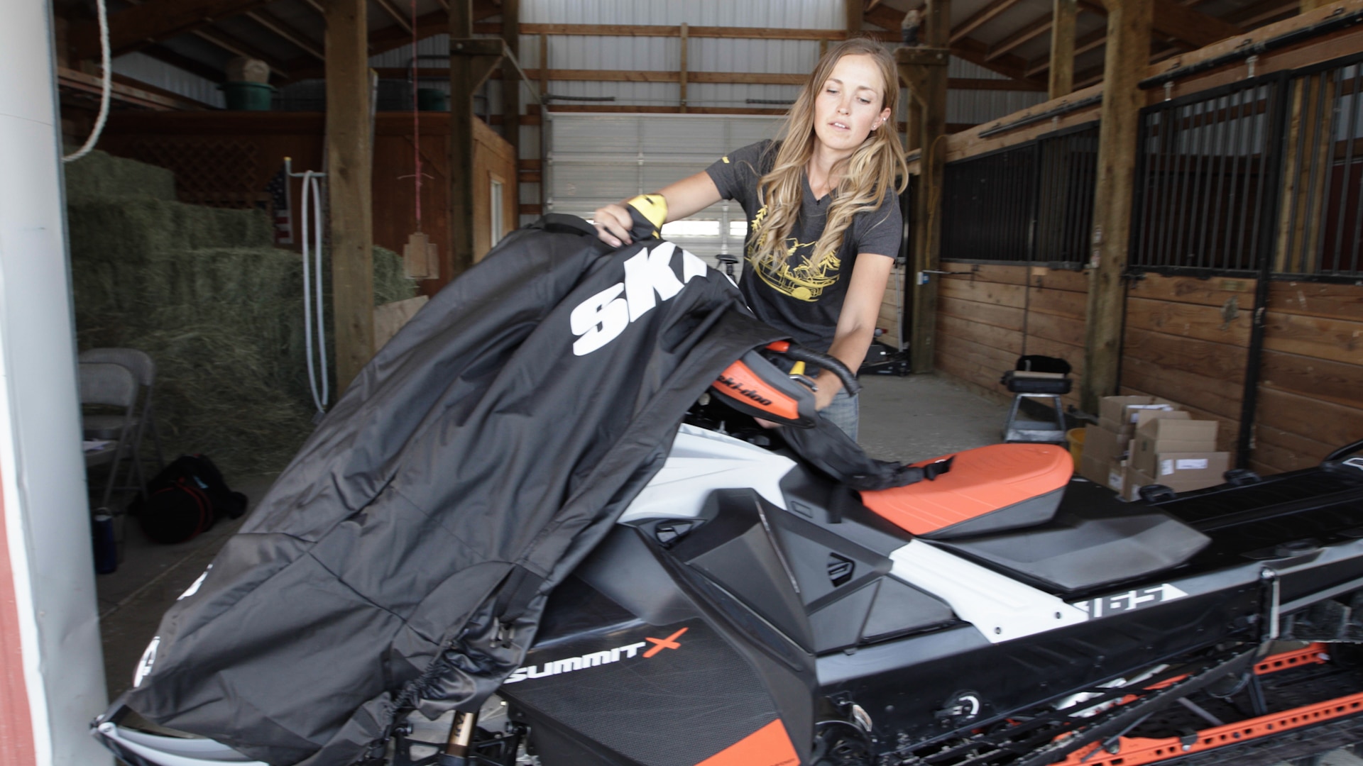 Ambassadrice Ski-Doo Stefanie Dean en train de couvrir sa motoneige avec un bâche