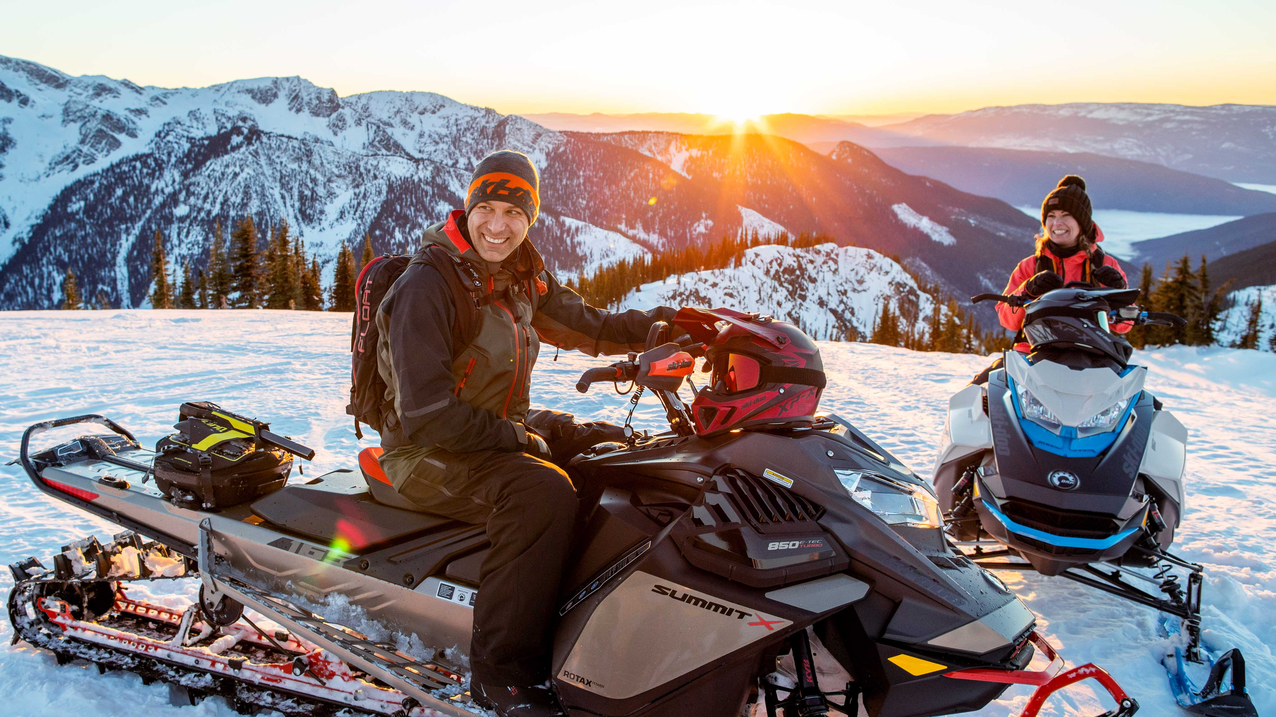 Couple enjoying a Snowmobile backcountry ride at sunset