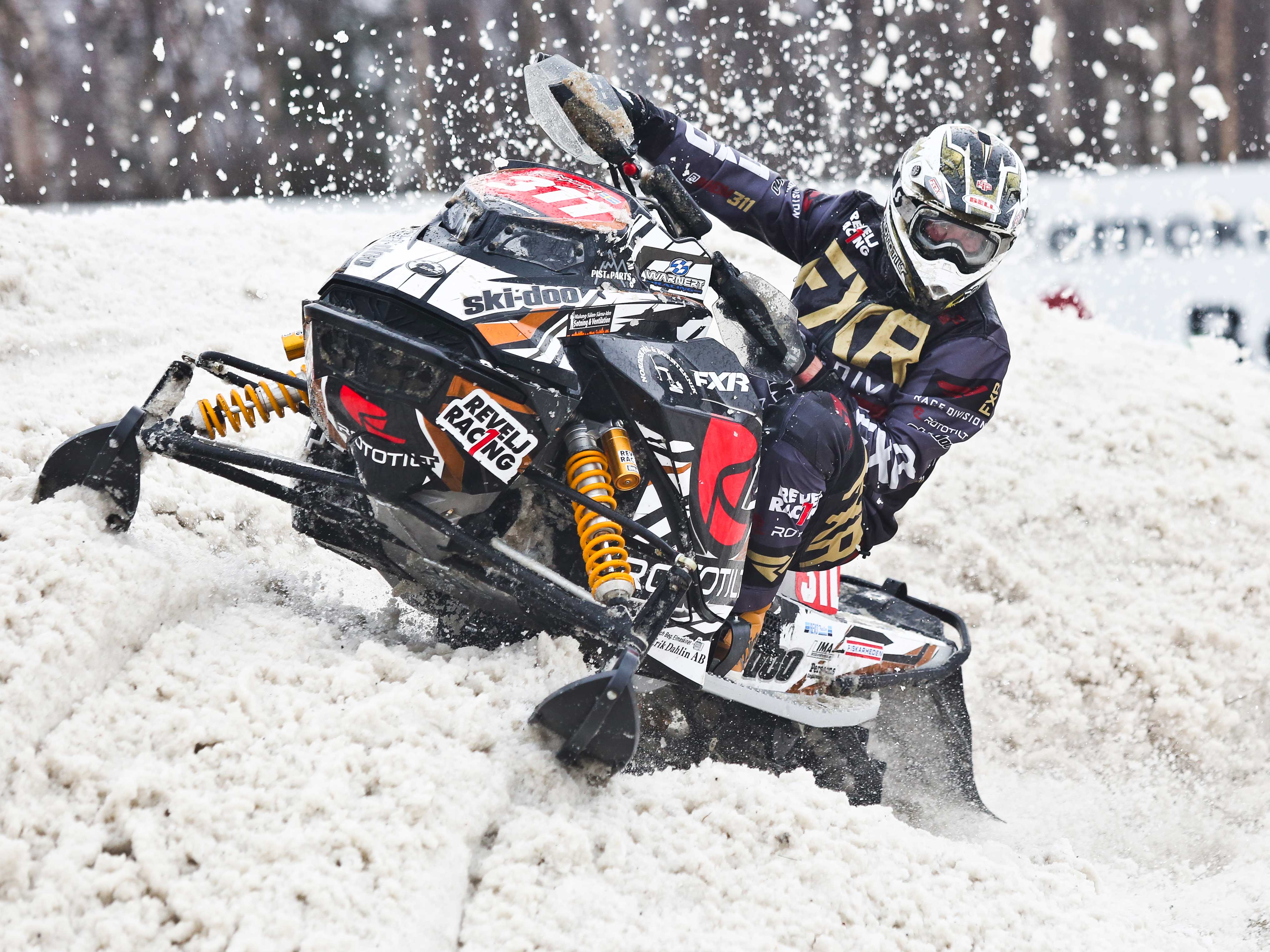 Adam Renheim carving during a snowmobile race