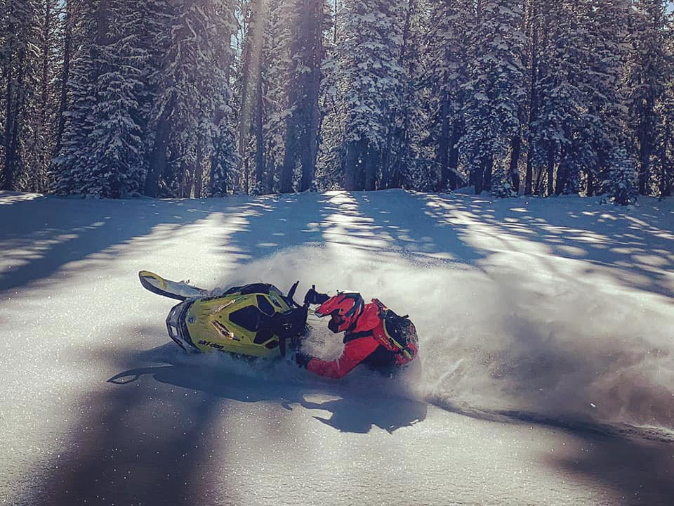 Ski-Doo ambassador riding his Ski-Doo in a snowy forest