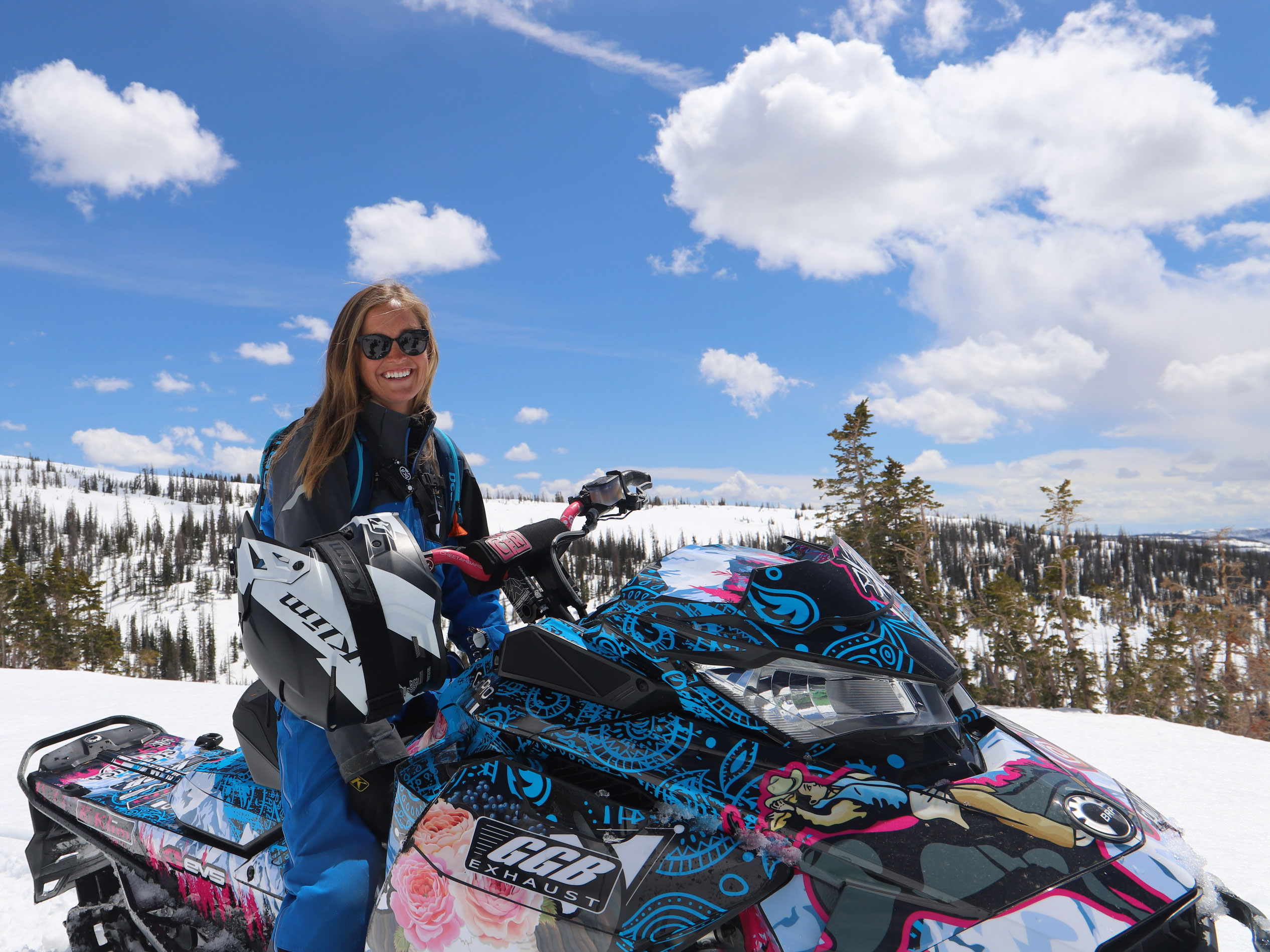 Stefanie Dean, amabassdrice Ski-Doo, assise sur sa motoneige avec un design personnalisé