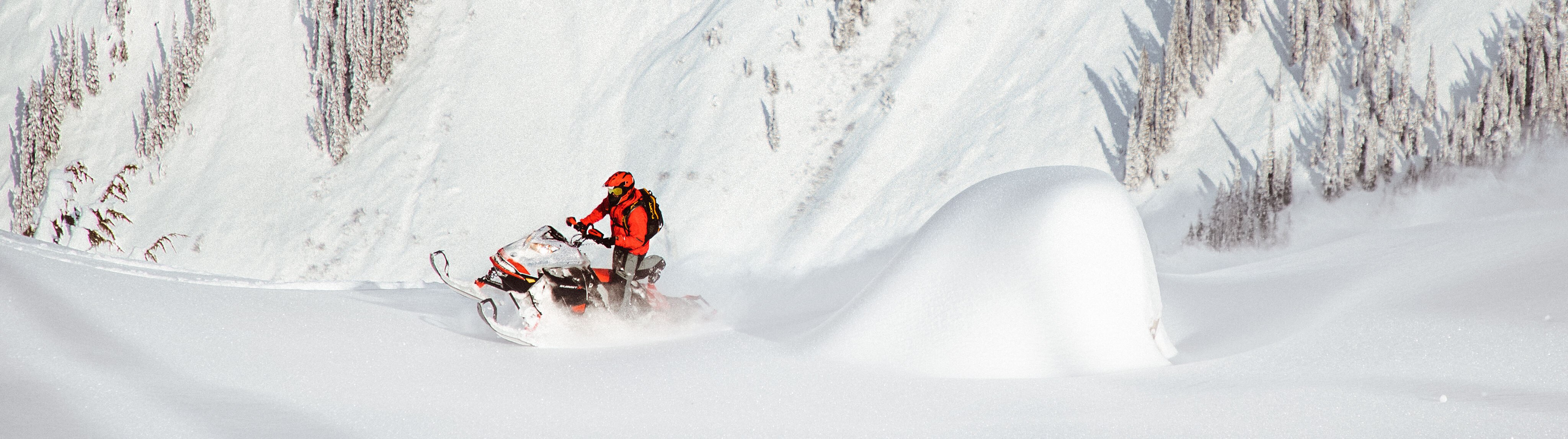 Man riding a Ski-Doo snowmobile in Deep-Snow