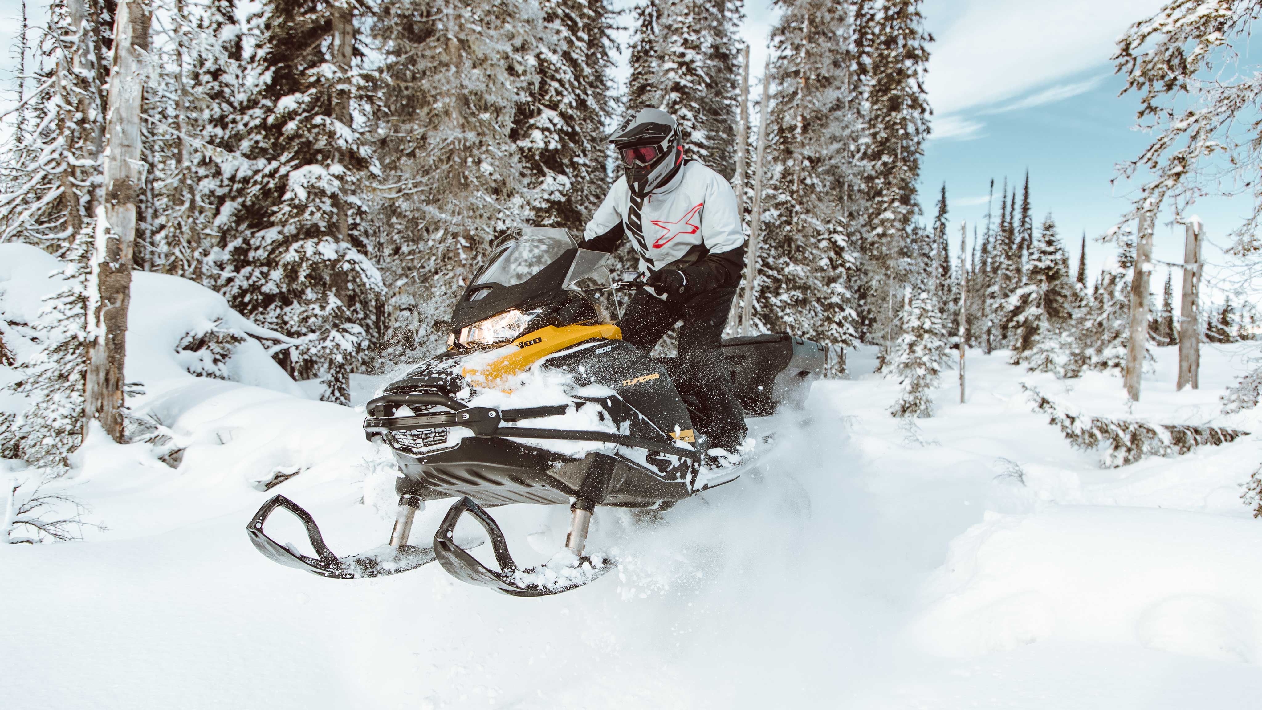 Pilote de motoneige debout sur son Ski-Doo Tundra