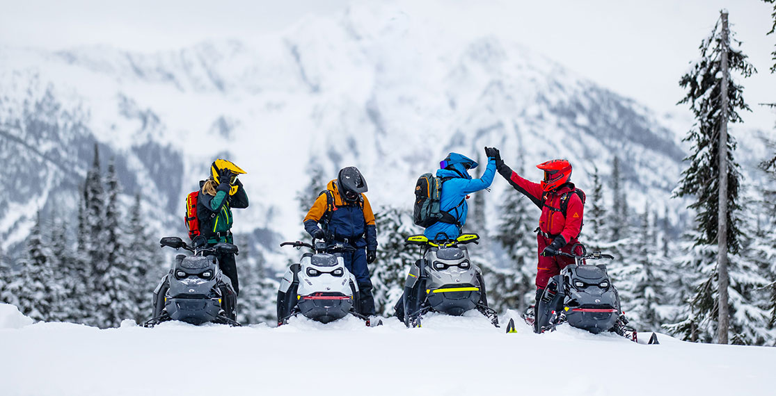 People cheering on their Ski-Doo on the snow