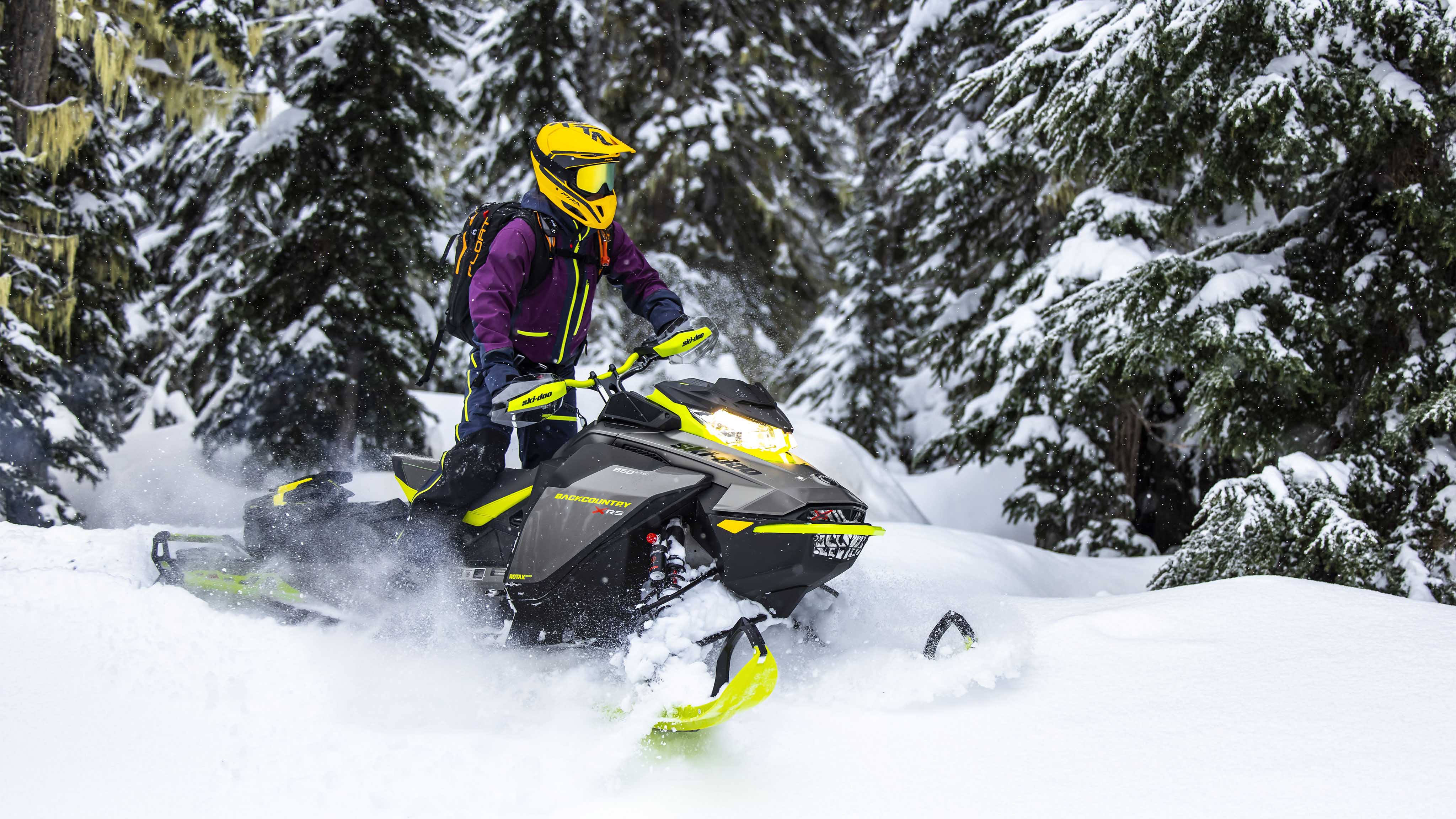 Femme debout sur sa motoneige Ski-Doo Backcountry 2023