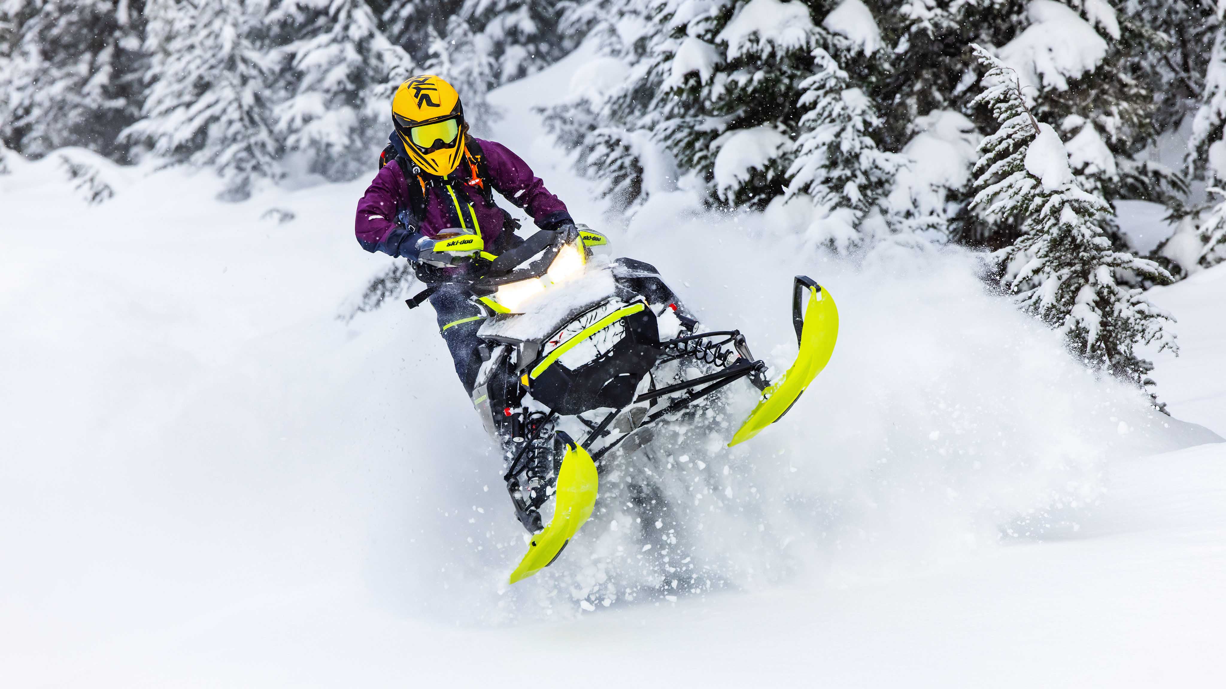 Femme pilotant dans la neige profonde avec une motoneige Hybride Ski-Doo