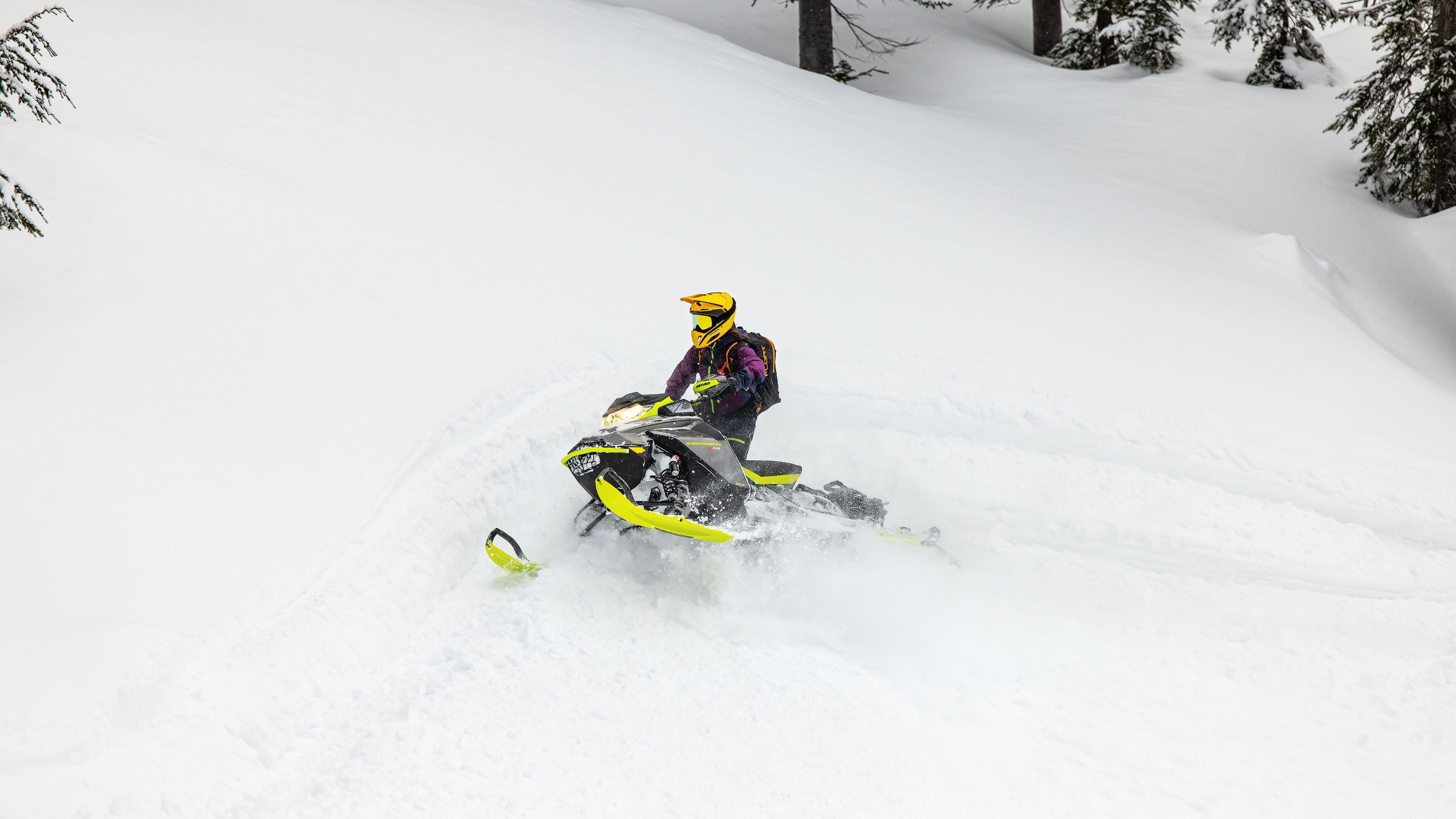 " Homme pilotant dans la neige profonde avec une motoneige Hybride Ski-Doo "