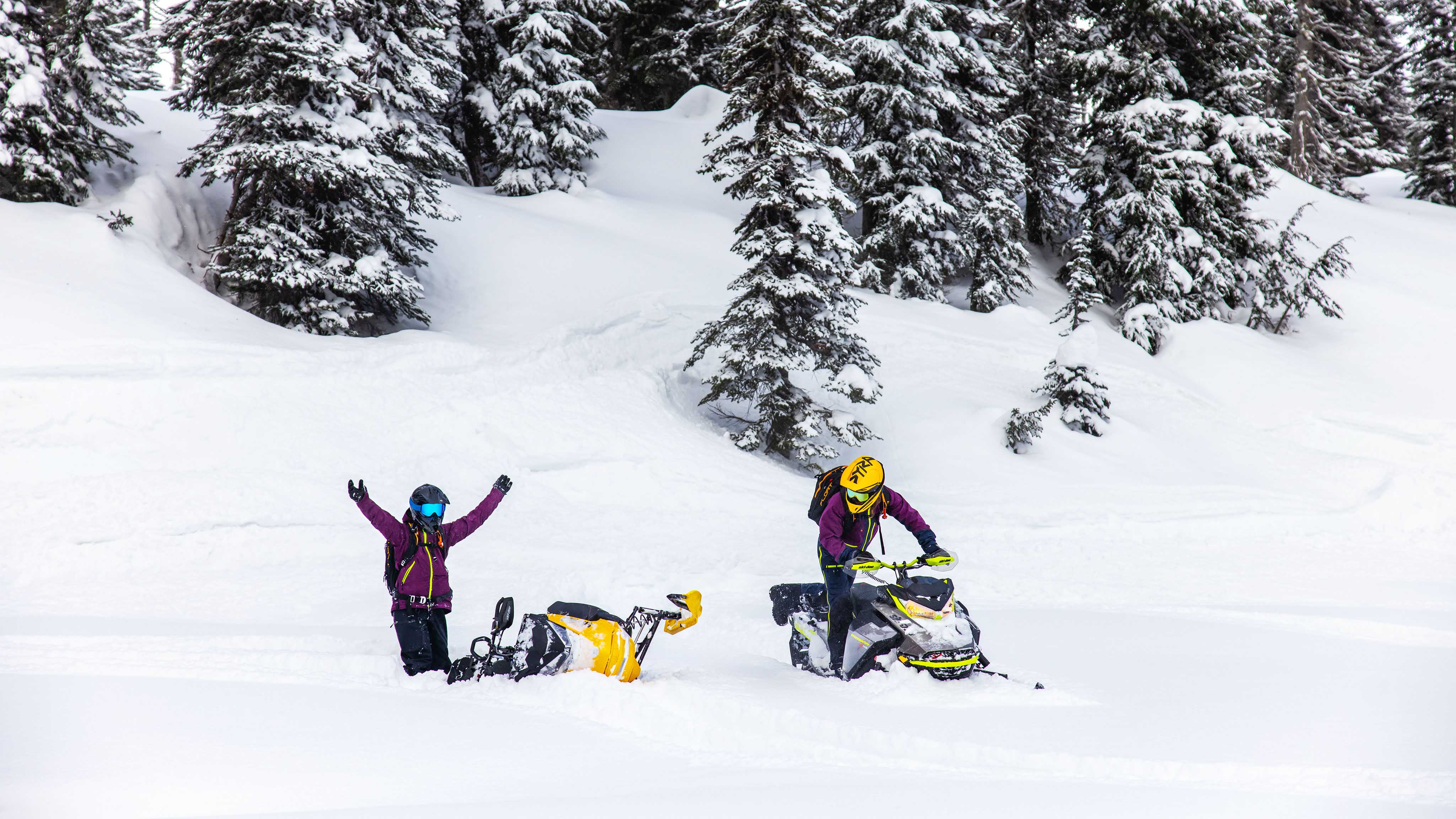Deux femmes en train d'apprendre à conduire des motoneiges Ski-Doo en neige profonde