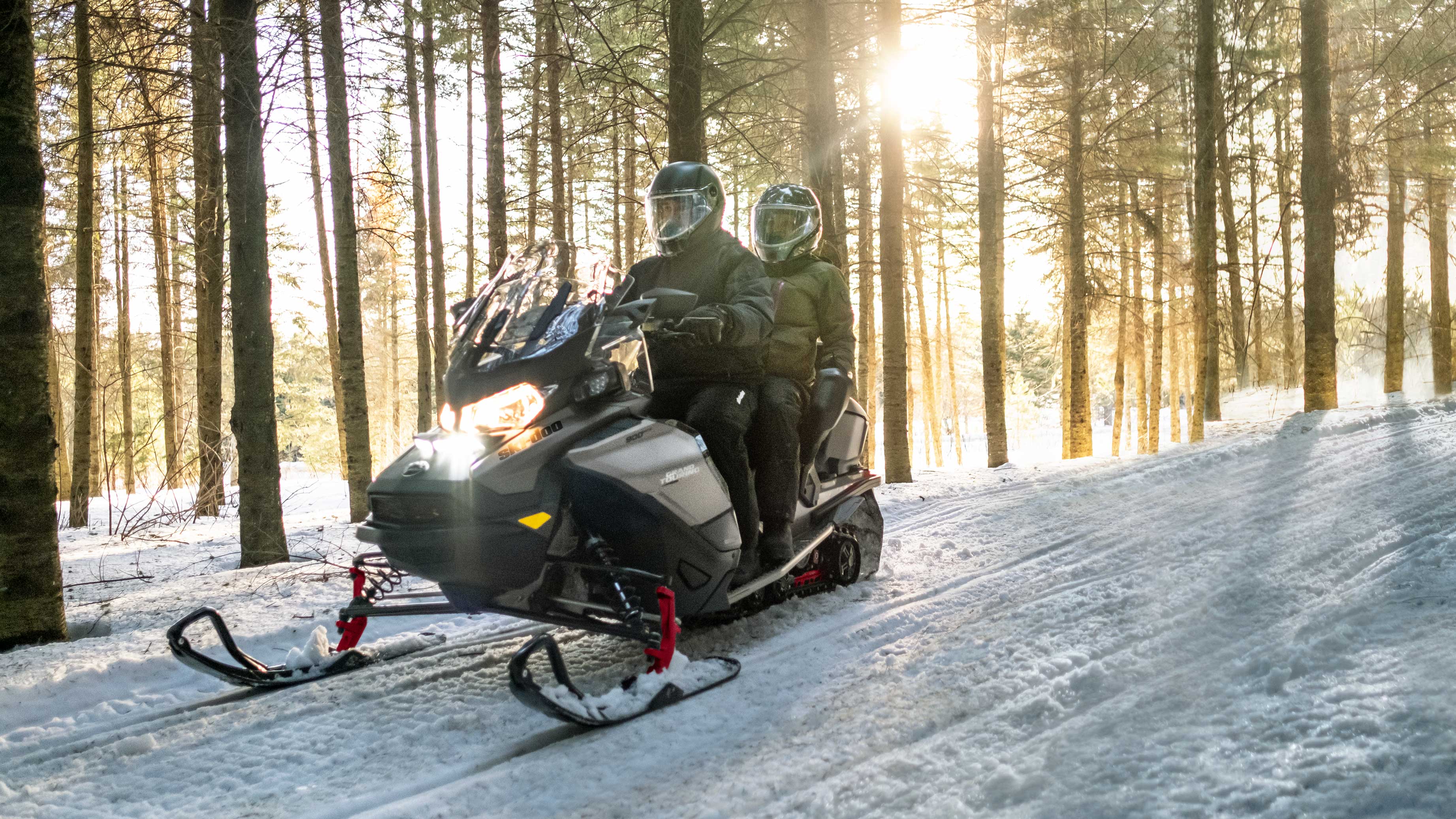 Couple riding 2022 Ski-Doo Grand Touring snowmobile
