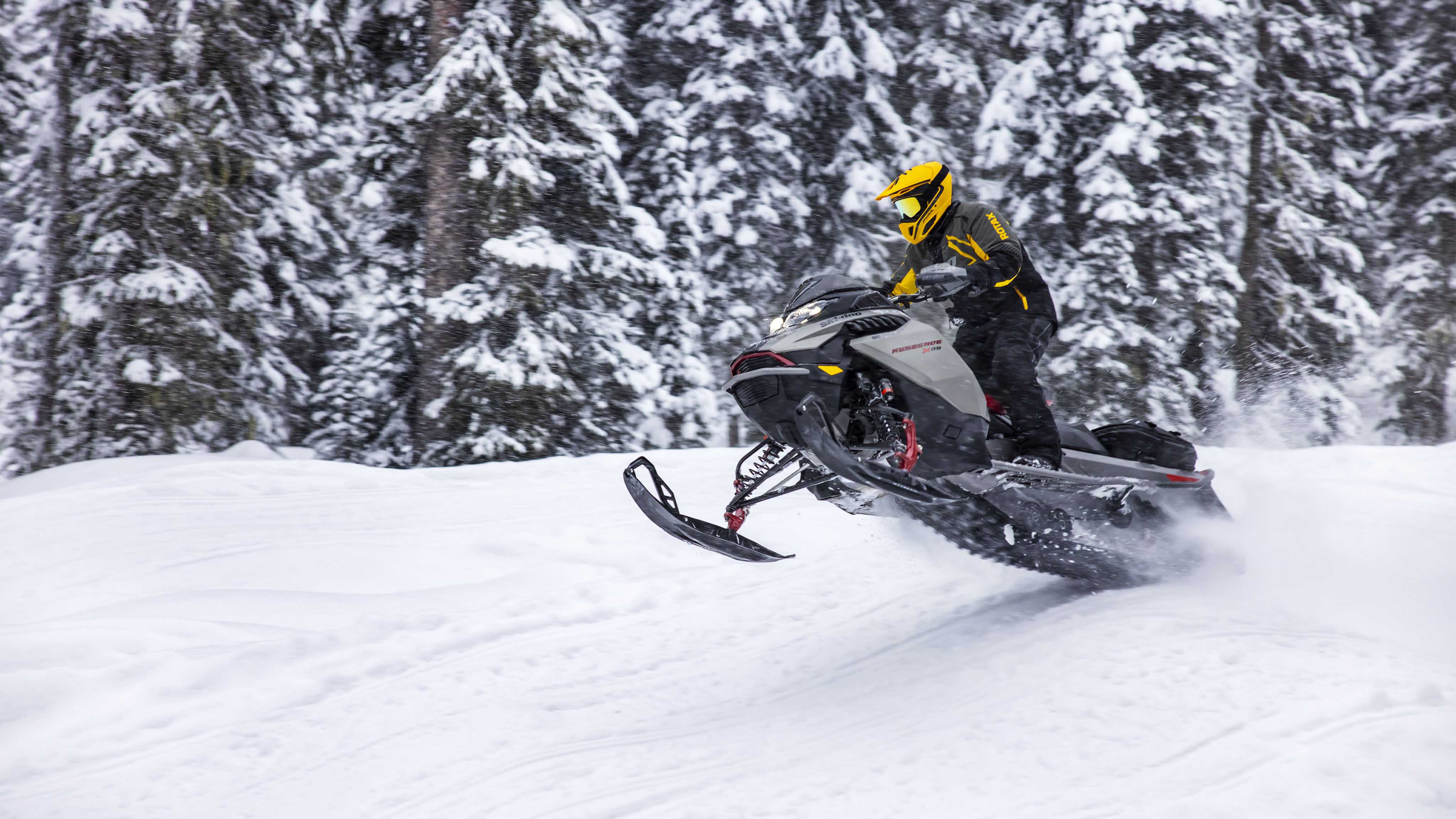 Homme roulant à vive allure sur une piste de motoneige avec le nouveau Ski-Doo Renegade