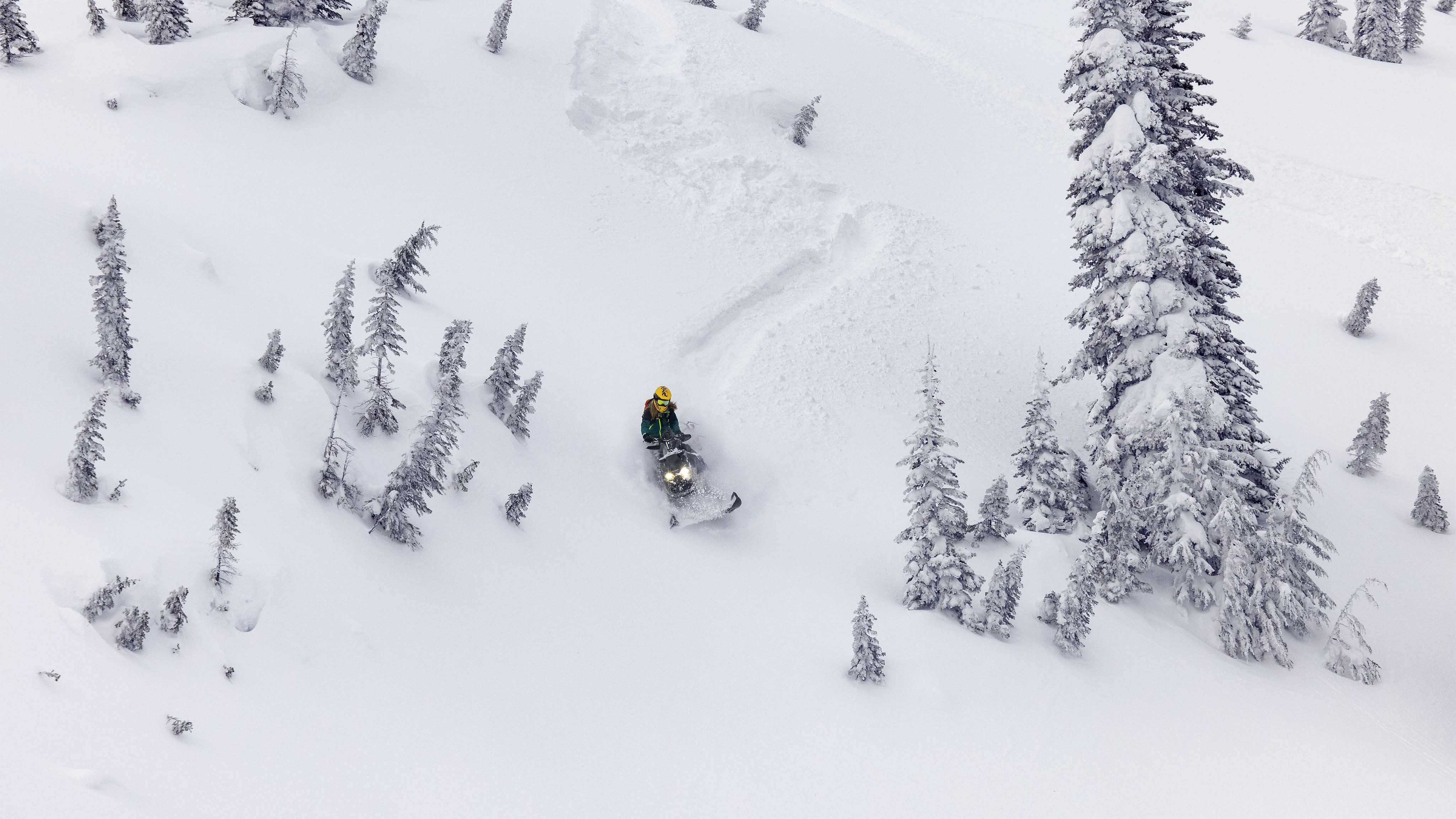 Woman riding a Ski-Doo Summit in deep snow