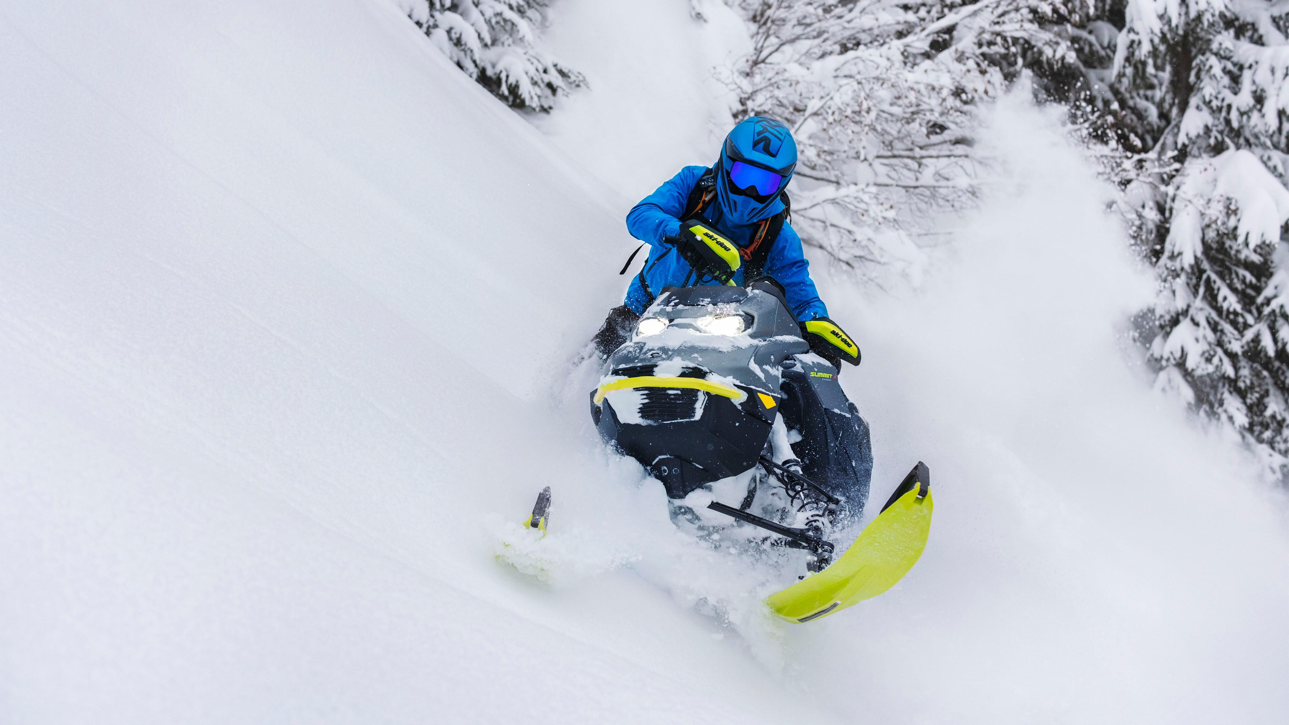 Conducteur de motoneige carve dans la neige profonde avec le Ski-Doo Summit 2023