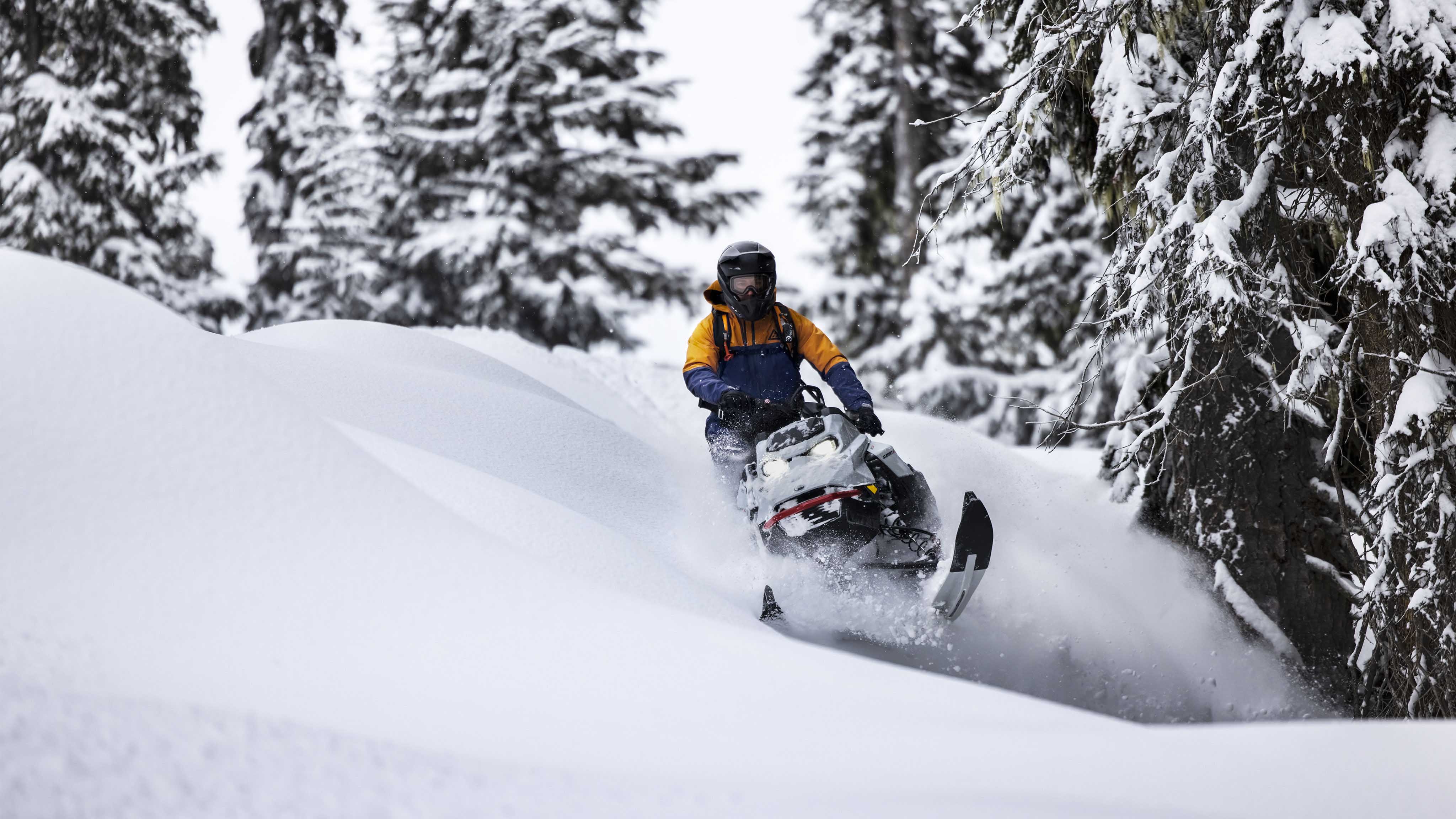 Homme conduisant le nouveau Ski-Doo Summit dans la neige profonde