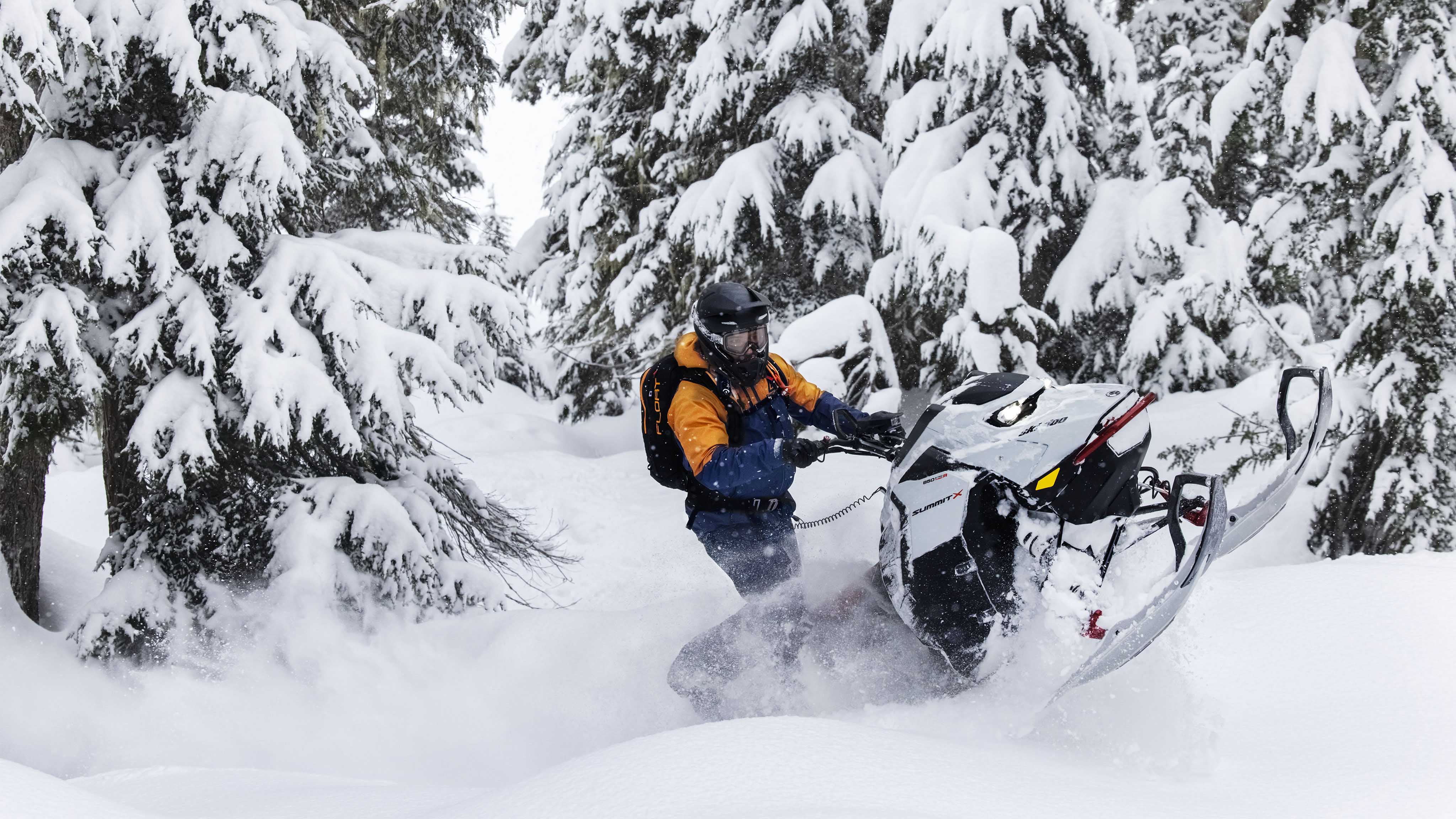 Homme sur une motoneige Ski-Doo Summit X portant les vêtements BC Kona+