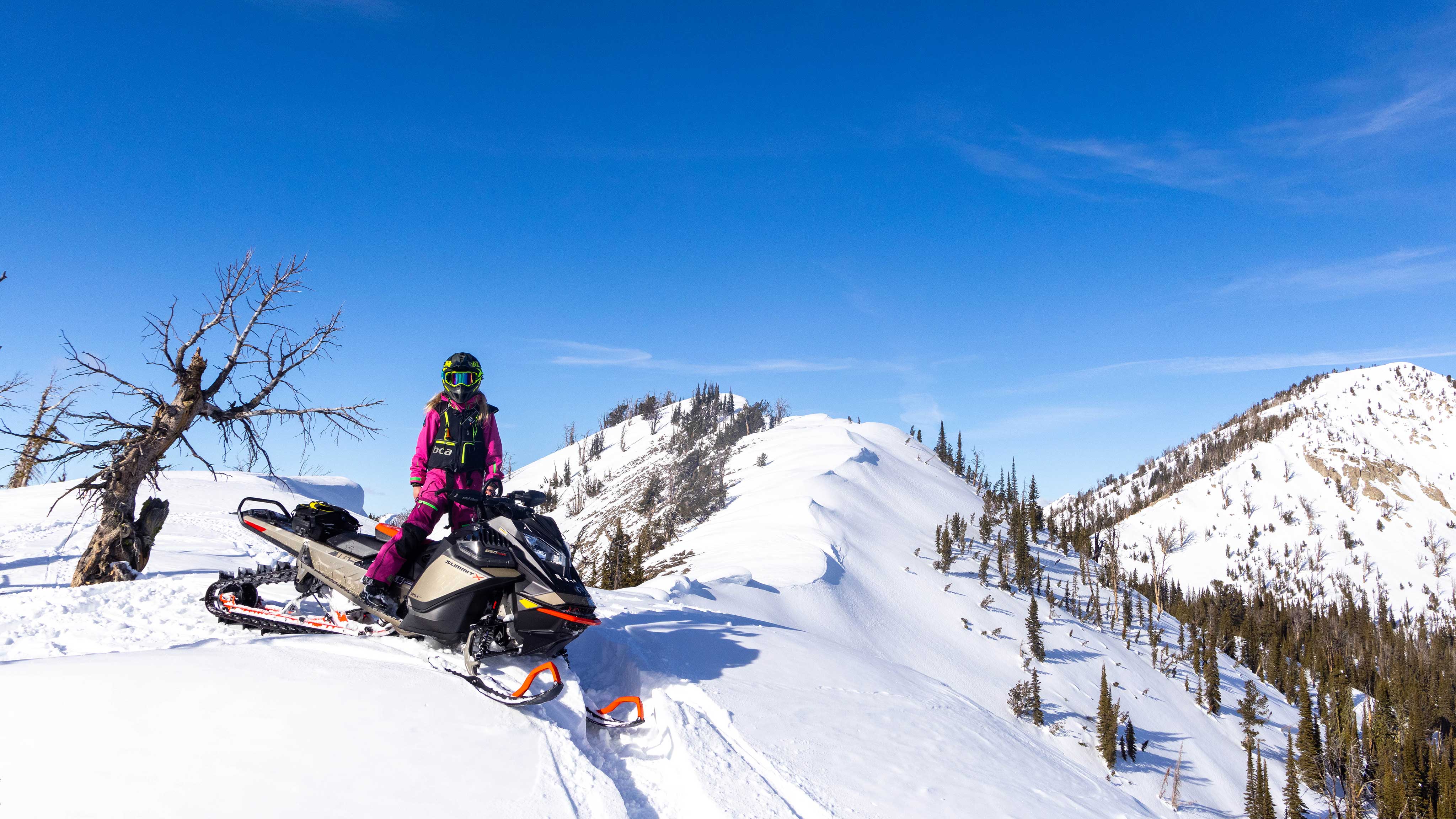 Lisa Granden at the top of a mountain on her Ski-Doo snowmobile