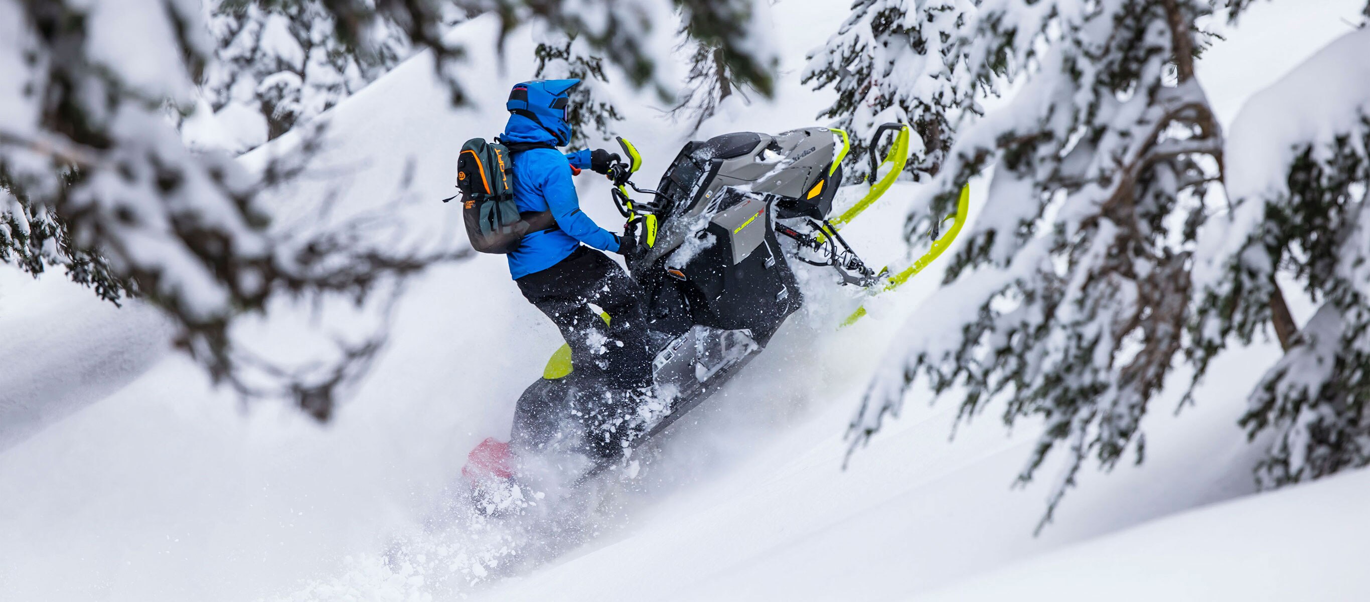 Man driving the Ski-Doo Summit snowmobile in the woods
