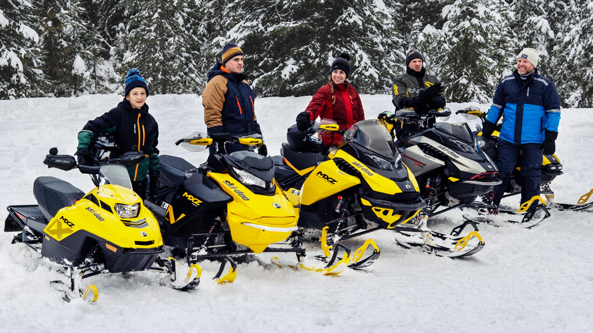 Group of friends next to their Ski-Doo snowmobile