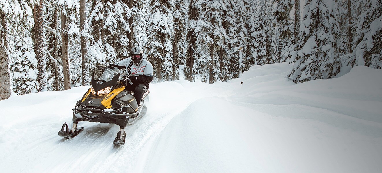 Man taking a turn on a snowmobile trail with a Ski-Doo Tundra